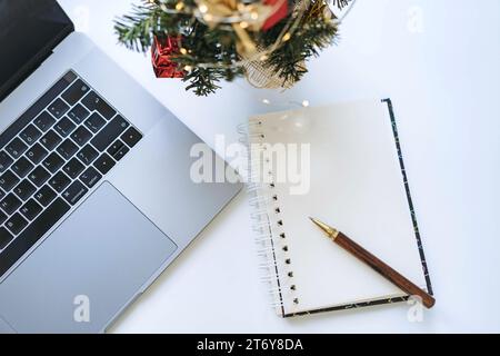 open notepad with blank sheet and pen. Laptop and smartphone on background. New year plans and resplutions concept Stock Photo