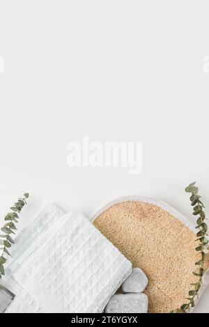 Circular loofah body scrubber cotton napkin spa stones with twigs isolated white background Stock Photo