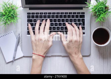 Crop hand using laptop near coffee notebook Stock Photo