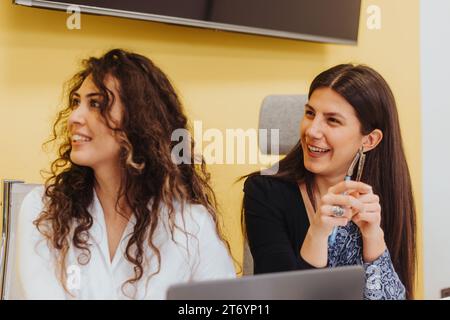 Young women collaborates in a modern office, fostering a positive and innovative environment. Stock Photo