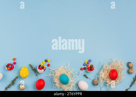 Colored eggs nests with small candies table Stock Photo