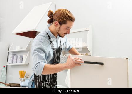 Handsome young man opening fridge Stock Photo