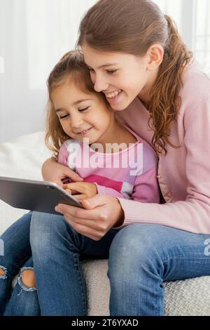 Two sisters using tablet together home Stock Photo