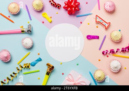 White blank circle frame surrounded with aalaw sprinkles streamers balloon candles colored backdrop Stock Photo