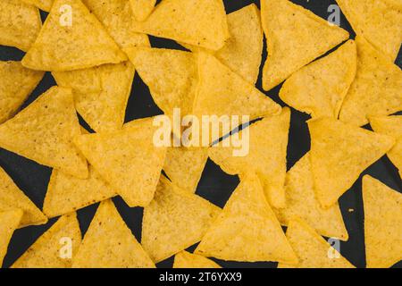 Yellow mexican nachos chips black background Stock Photo