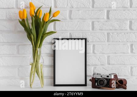 Bouquet tulips transparent vase with empty frame camera Stock Photo