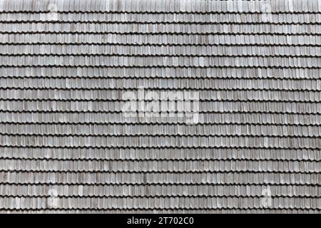 Gray wooden roof tiles background texture. A close up of old gray roof covered with wooden tiles or shingles Stock Photo