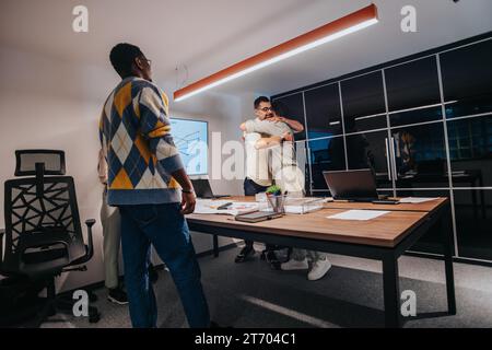 Multiracial Team of Architects and Engineers Discussing Blueprint in a Boardroom Stock Photo