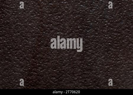 Dark textured background image resembling divoted or dimbled brown stone. Stock Photo