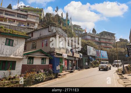 Darjeeling city road with toy train tracks, shops, and tourists. Darjeeling is popular hill station in the state of West Bengal, India. Stock Photo