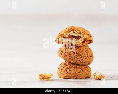 Stack of cookie amaretti on white marble background - traditional Italian Sardinian pastry. Delicious amaretti biscuit cookies made from almond or apricot kernels with copy space Stock Photo