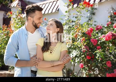 Lovely young couple dancing together outdoors on sunny day Stock Photo