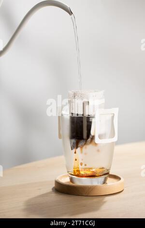 The hot water is poured over the roasted and ground coffee, in a filter paper ready to use. Stock Photo