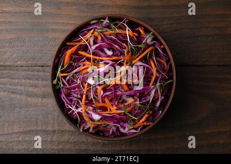 Tasty salad with red cabbage in bowl on wooden table, top view Stock Photo