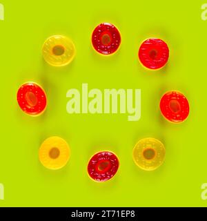 Circle of round jelly candies lie on light green background. Bold surface with delicious round sweets Stock Photo