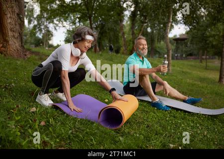 Seniors getting ready for yoga training and meditation outdoors Stock Photo