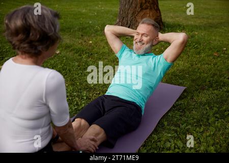 Happy married couple of retirees doing training workout in park Stock Photo