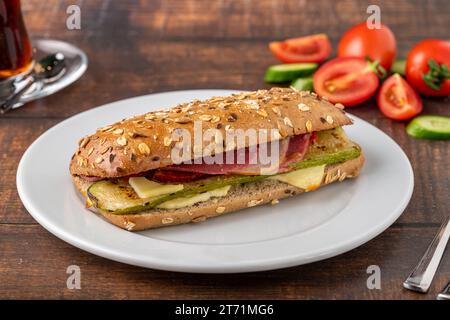 Vegetable and ham sandwich with tea on wooden table Stock Photo