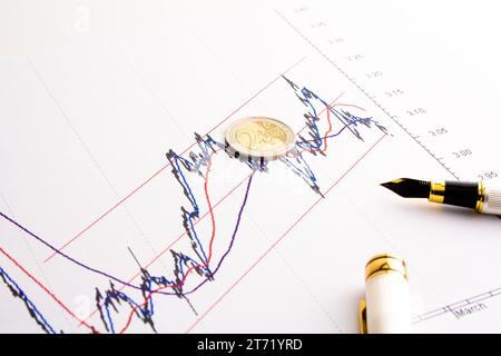 detail of euro coin on financial spread btp bund chart ; detail of euro coin on financial spread btp bund chart Stock Photo