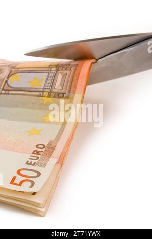detail of used banknotes of euro and scissors on white background Stock Photo