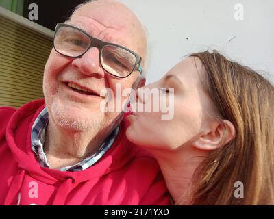 junge frau küsst älteren mann auf die wange junge frau küsst älteren mann auf die wange *** young woman kisses older man on the cheek young woman kisses older man on the cheek Credit: Imago/Alamy Live News Stock Photo