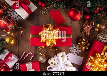 Decorating Christmas gifts background. Mother and child hands wrapping stack on New Year and Christmas gift boxes with festive ribbon, preparation for Stock Photo