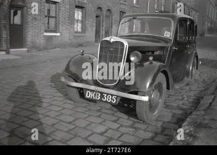 1950s, historical, a motor car of the era parked on a cobbled street of small victorian terraced houses, Oldham, Manchester, England, UK. Stock Photo