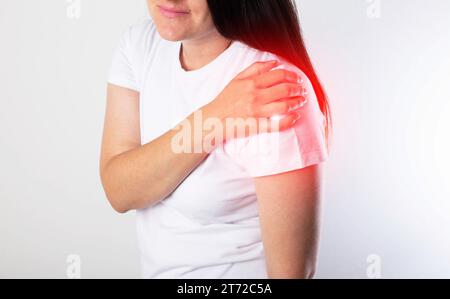 A girl has pain in her shoulder due to a pinched nerve in the cervical spine, osteochondrosis of the spine. Referred pain Stock Photo