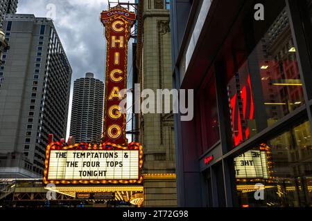 The Chicago Theatre featuring the Temptations and the four Tops in Chicago, United States. In the background is one of the two marina towers, one of the city's most famous buildings in the shape of a corn cob Stock Photo