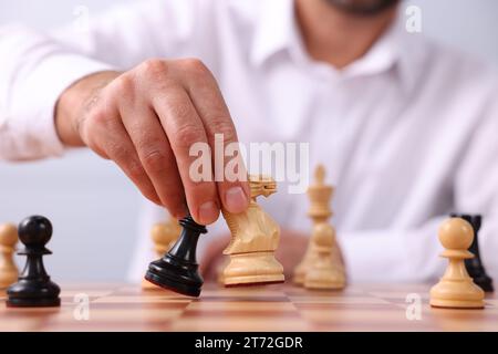 Man moving chess pieces on checkerboard, closeup Stock Photo