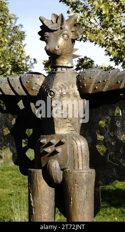 A high-resolution close-up photograph of an ornately carved stone bird statue perched atop a decorative stand Stock Photo