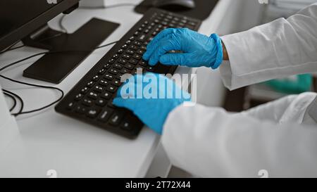 Handsome middle age man, a dedicated scientist, typing vital data on keyboard, immersed in a world of science in his lab Stock Photo