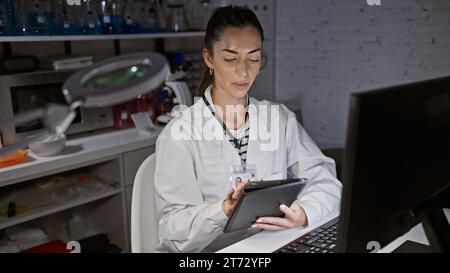 Young beautiful hispanic woman scientist using computer and touchpad at laboratory Stock Photo