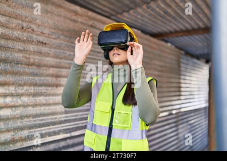 Young beautiful hispanic woman architect using virtual reality glasses at street Stock Photo