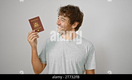 Cheerful young man joyfully flashing his philippine passport, standing confidently isolated against a pure white background Stock Photo