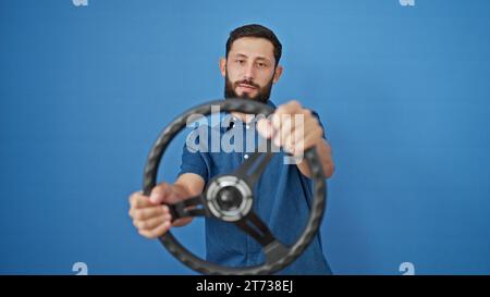Young hispanic man using steering wheel as a driver over isolated blue background Stock Photo