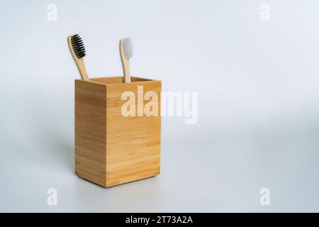 two toothbrushes in bamboo holder on white background Stock Photo