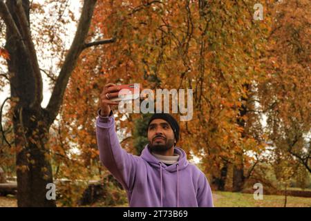 Srinagar, India. 10th Nov, 2023. November 10, 2023, Srinagar Kashmir, India : A Visitor takes selfie pictures at the Mughal Garden covered with fallen leaves of mighty Chinar trees in Nishat at Srinagar. Autumn colors are reaching their peak with trees, particularly Chinar, changing their colors as the days are becoming shorter. On November 10, 2023, Srinagar Kashmir, India. (Photo By Firdous Nazir/Eyepix Group/Sipa USA) Credit: Sipa USA/Alamy Live News Stock Photo