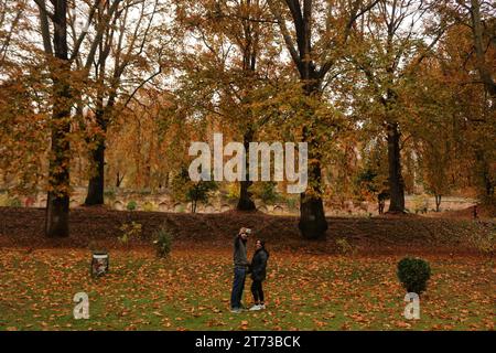 Srinagar, India. 10th Nov, 2023. November 10, 2023, Srinagar Kashmir, India : Visitors take selfie pictures at the Mughal Garden covered with fallen leaves of mighty Chinar trees in Nishat at Srinagar. Autumn colors are reaching their peak with trees, particularly Chinar, changing their colors as the days are becoming shorter. On November 10, 2023, Srinagar Kashmir, India. (Photo By Firdous Nazir/Eyepix Group/Sipa USA) Credit: Sipa USA/Alamy Live News Stock Photo