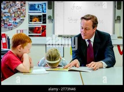 London, UK. 08th Apr, 2015. Image © Licensed to Parsons Media. 13/11/2023. London, United Kingdom. David Cameron appointed Foreign Secretary. Bolton, United Kingdom. The Prime Minister David Cameron and Nicky Morgan Education Secretary help Lucy Howarth 6 and Will Spibey 5 (red T shirt), read while on a visit to Sacred Heart Catholic Primary School, near Bolton, on Day 10 of his General Election Campaign. Photo Picture by Credit: andrew parsons/Alamy Live News Stock Photo