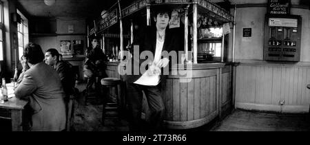 Legendary Irish rockstar, singer/songwriter & frontman for The Pogues & The Popes, Shane MacGowan pictured drinking and smoking at his favourite London pub Filthy MacNasty’s , Islington 1994 Stock Photo