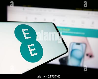 Cellphone with logo of British telecommunications company EE Limited in front of business website. Focus on center-left of phone display. Stock Photo