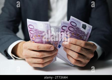 closeup of businessman hands counting 500 euro money banknotes Stock Photo