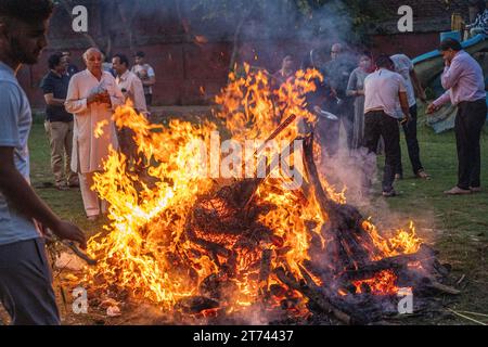 people dancing around a huge bon fire on the hindu festival of holi lohri celebrating the festival of colours and a good harvest and the end of winter Stock Photo