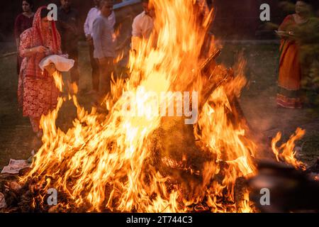 people dancing around a huge bon fire on the hindu festival of holi lohri celebrating the festival of colours and a good harvest and the end of winter Stock Photo