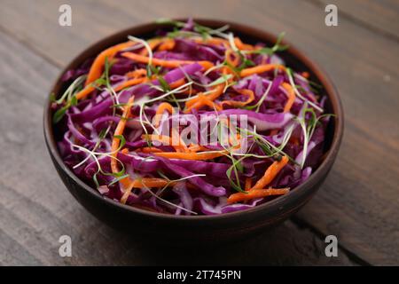 Tasty salad with red cabbage in bowl on wooden table, closeup Stock Photo