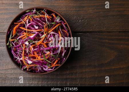 Tasty salad with red cabbage in bowl on wooden table, top view. Space for text Stock Photo