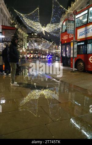 UK weather, London, 12 November 2023: Christmas lights on Regent Street are reflected from wet roads on a rainy night. Anna Watson/Alamy Live News Stock Photo