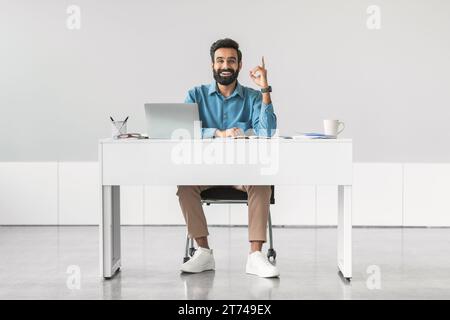 Indian businessman having idea, sitting at desk Stock Photo