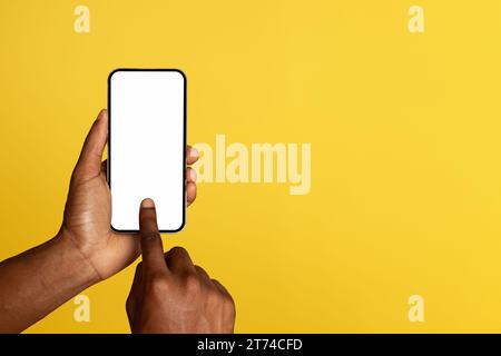 Hands of young black man use mobile phone with empty screen, chatting in social networks Stock Photo